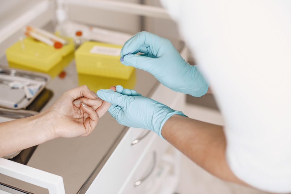 Un profesional de la salud con guantes toma una muestra de sangre de un paciente. Entorno médico.