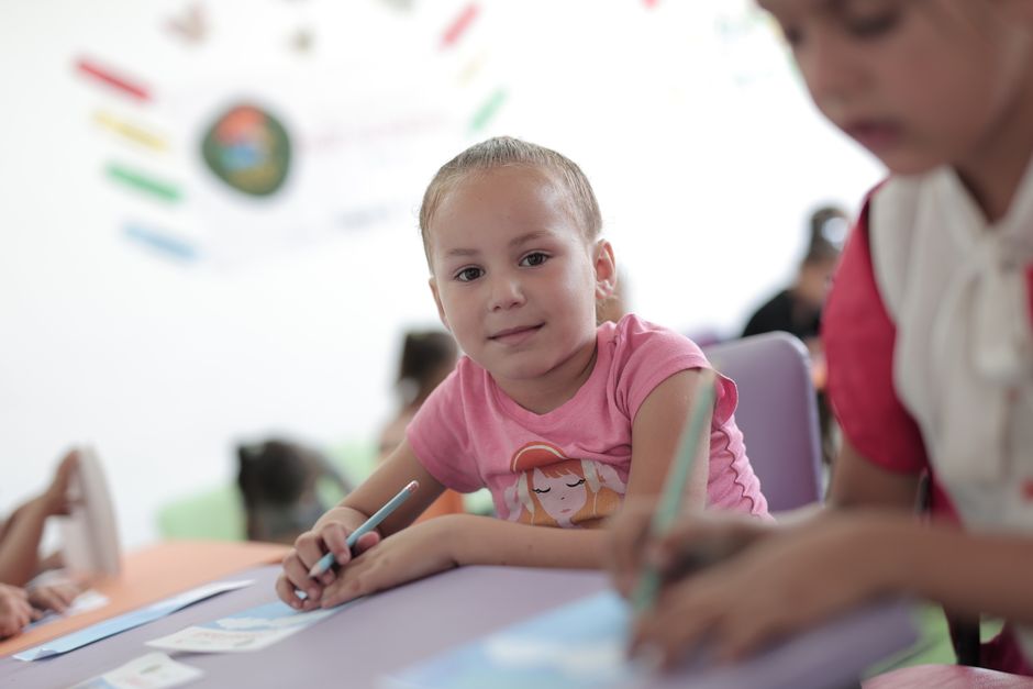 Los niños pequeños participan activamente en actividades creativas en un entorno de aula, fomentando así el aprendizaje y el desarrollo.