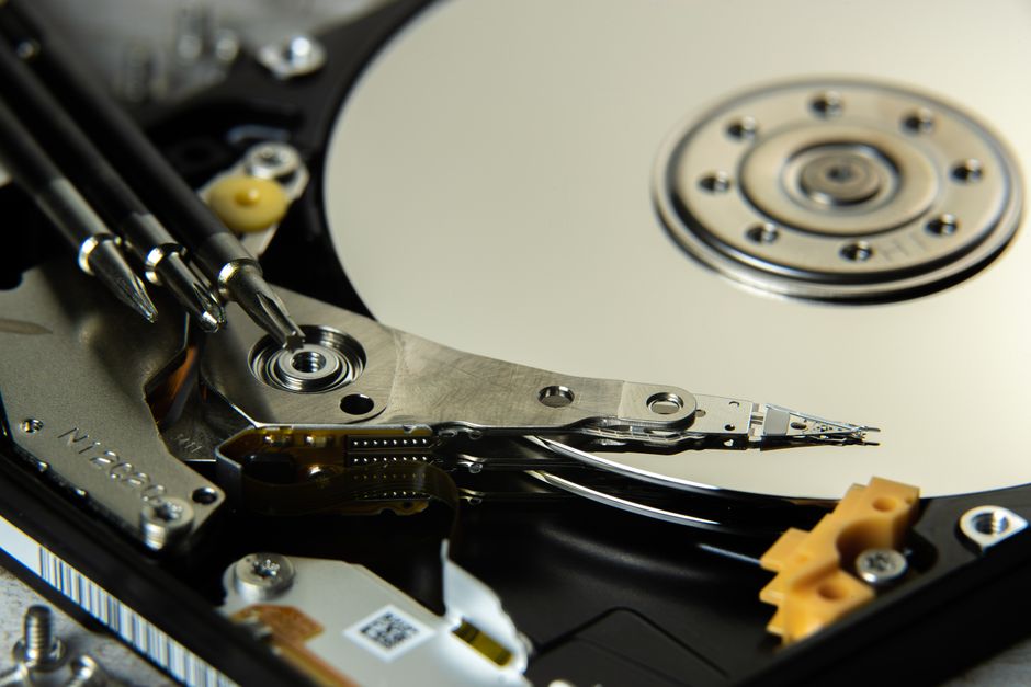 Vista detallada de los platos internos del disco duro y cabezales de lectura/escritura para tecnología de almacenamiento de datos.