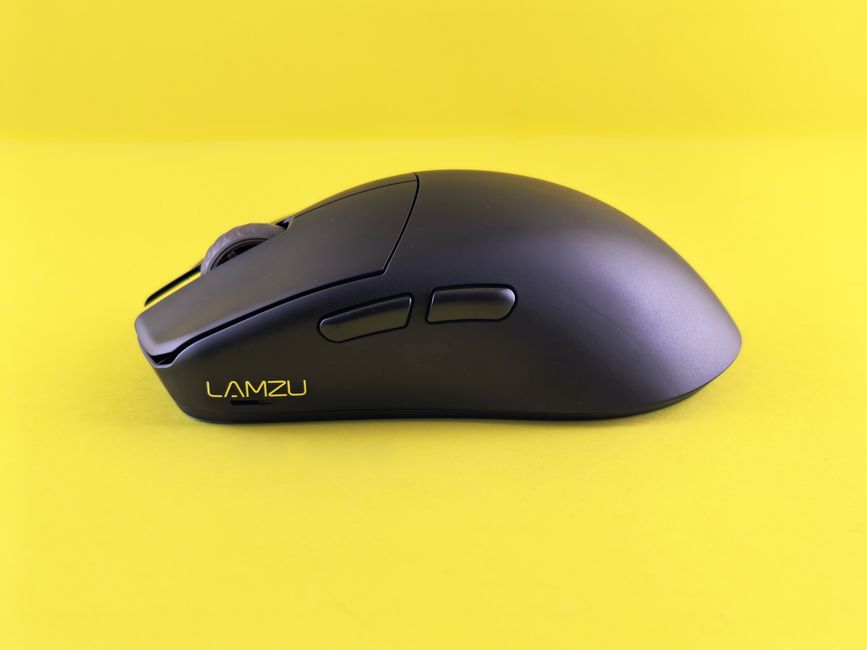 Ratón inalámbrico negro moderno con botones laterales sobre un vibrante fondo amarillo.