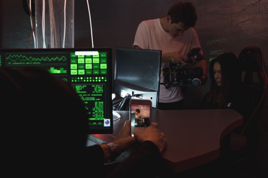 Un equipo trabaja en una configuración de filmación tecnológica mostrando monitores y equipo.