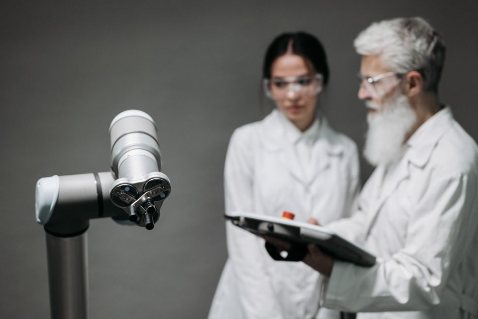 Investigadores con batas de laboratorio analizan equipos robóticos para el avance tecnológico.
