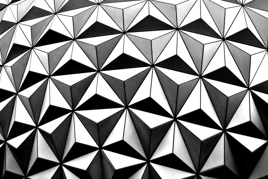 Patrón geométrico intrincado en blanco y negro con formas triangulares creando un efecto de mosaico.