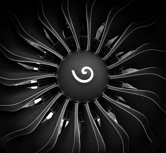 Resumen en blanco y negro del ventilador de un motor de turbina de avión que muestra aspas simétricas.