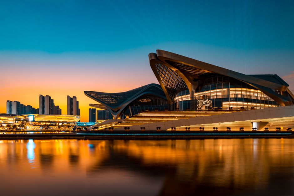 Impresionante arquitectura reflejada en el agua durante un vibrante atardecer urbano.