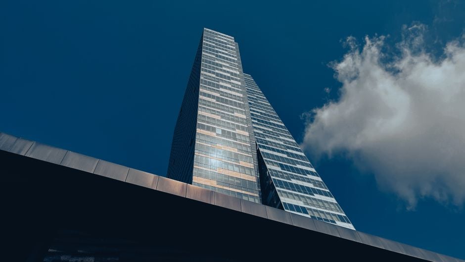 Vista cautivadora en ángulo bajo de un rascacielos en Estambul con un vibrante cielo azul y nubes.