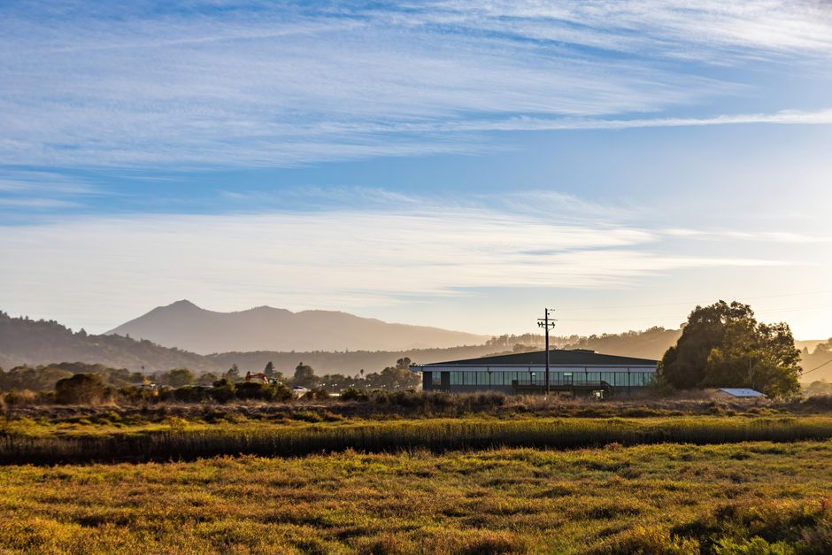 Escena rural serena con campos abiertos y montañas distantes al amanecer.