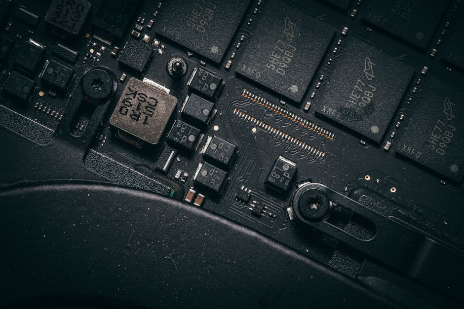 Fotografía macro detallada de una placa de circuito electrónico que muestra microchips y componentes.
