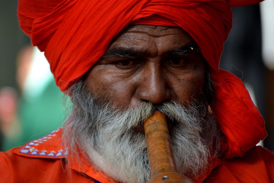 Retrato de un músico tradicional indio en Surajkund Mela, Haryana, tocando un instrumento hecho a mano.