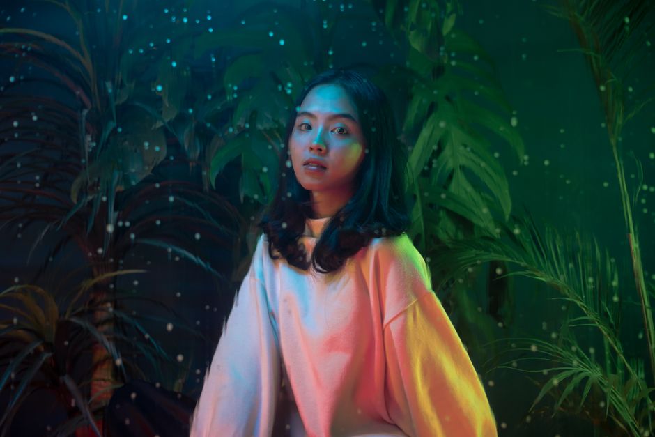 Retrato artístico de una mujer con luces coloridas y un ambiente de ensueño, evocando un estado de ánimo fantástico.