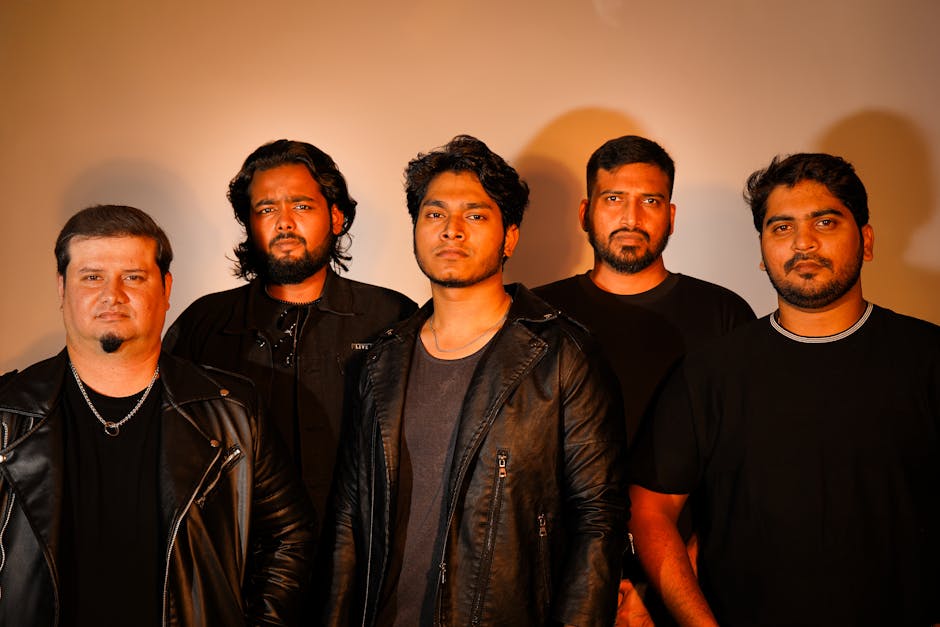 Retrato dinámico de una banda de rock posando con expresiones seguras en un entorno de estudio.