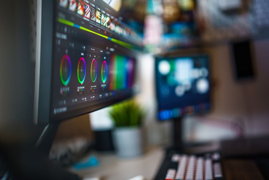 Espacio de trabajo moderno para la edición de vídeo con dos monitores que muestran herramientas de corrección de color.