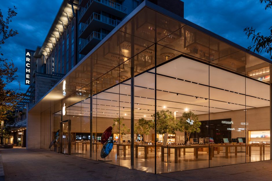 Impresionante vista del exterior de un edificio moderno de vidrio iluminado por la noche.
