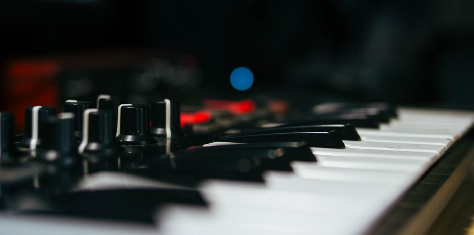 Vista detallada de un teclado electrónico y perillas de control, enfatizando la tecnología musical.