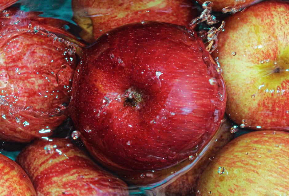 Vista de cerca de manzanas rojas sumergidas en agua, con gotas que realzan su frescura.