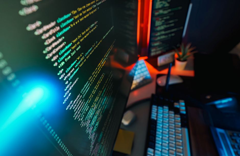 Espacio de trabajo futurista con una pantalla de computadora brillante con codificación mostrada, ideal para conceptos de tecnología y programación.