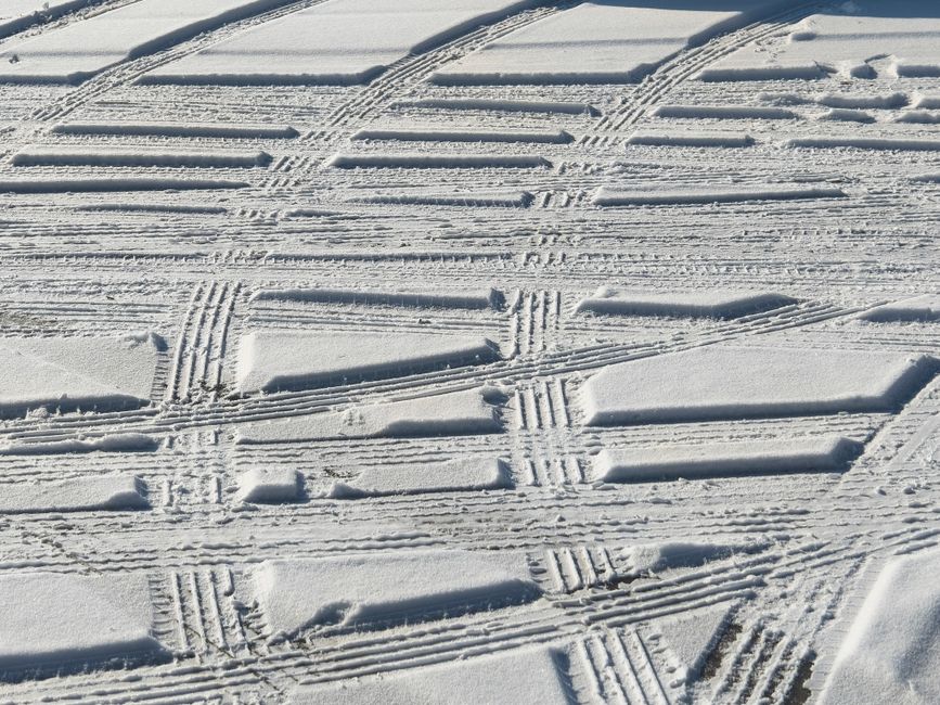 Patrones detallados de huellas de neumáticos en la nieve, capturando la esencia de las texturas invernales y la aventura al aire libre.