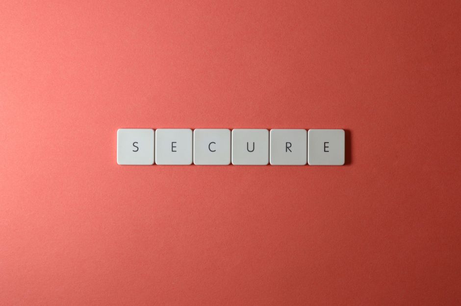 Un primer plano de la palabra 'Segura' formada con azulejos sobre una superficie roja, ideal para conceptos de seguridad.