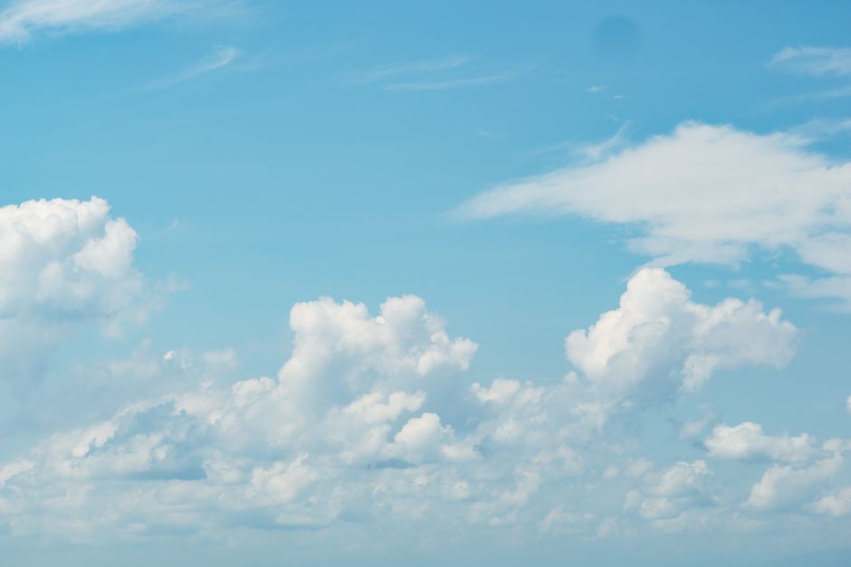 Una vista serena de nubes blancas esponjosas dispersas por un vibrante cielo azul, evocando paz y tranquilidad.