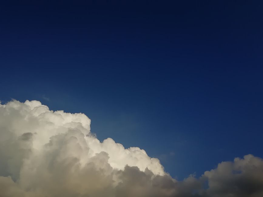 Cielo azul intenso con nubes cúmulos brillantes y esponjosas, que evocan una sensación de tranquilidad y asombro.