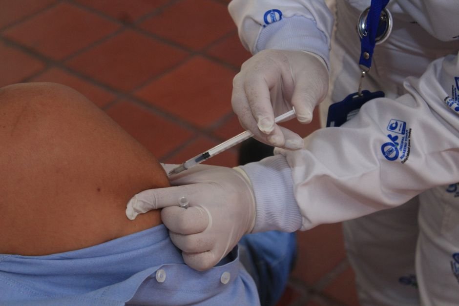 Personal sanitario aplica una inyección en el brazo de un paciente.