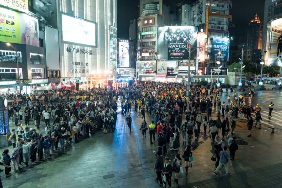 Una multitud animada se reúne en Ximending por la noche, mostrando la vibrante vida urbana de Taipei.