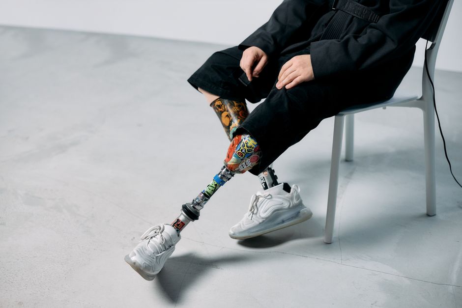 Piernas protéticas coloridas en un estudio minimalista, mostrando innovación y tecnología.