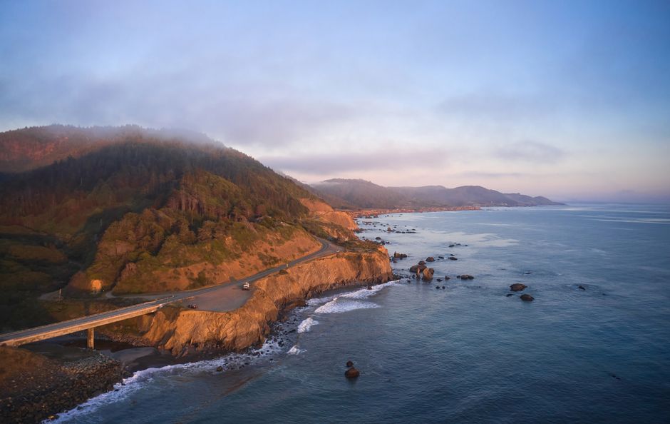 Una impresionante vista aérea de la pintoresca costa de Westport al atardecer, con océano y acantilados escarpados.