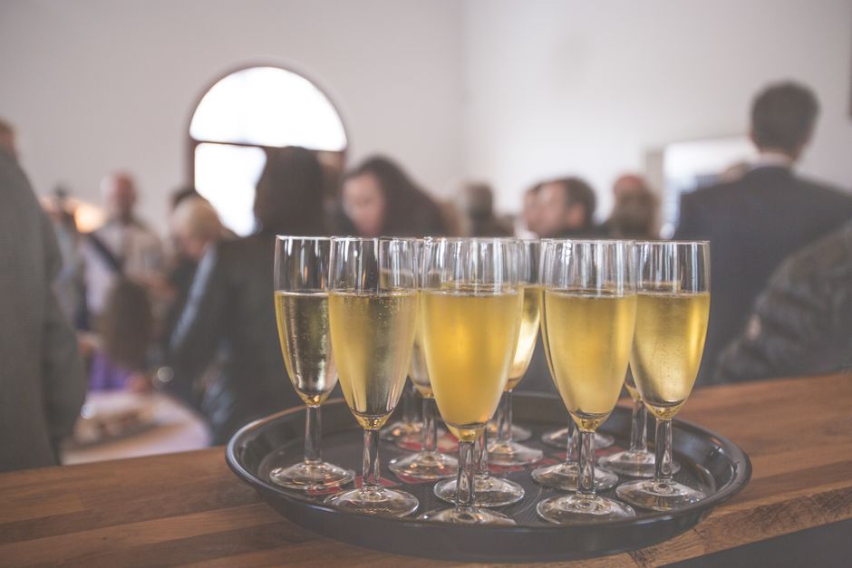 Un evento sofisticado con copas de champán en una animada reunión social en interiores.