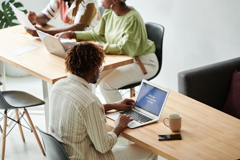 Grupo de colegas trabajando juntos en una sala de reuniones moderna y luminosa.