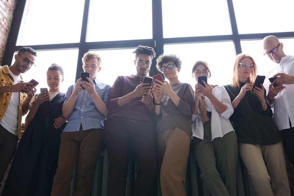 Personas De Pie Junto A La Ventana Usando Sus Teléfonos