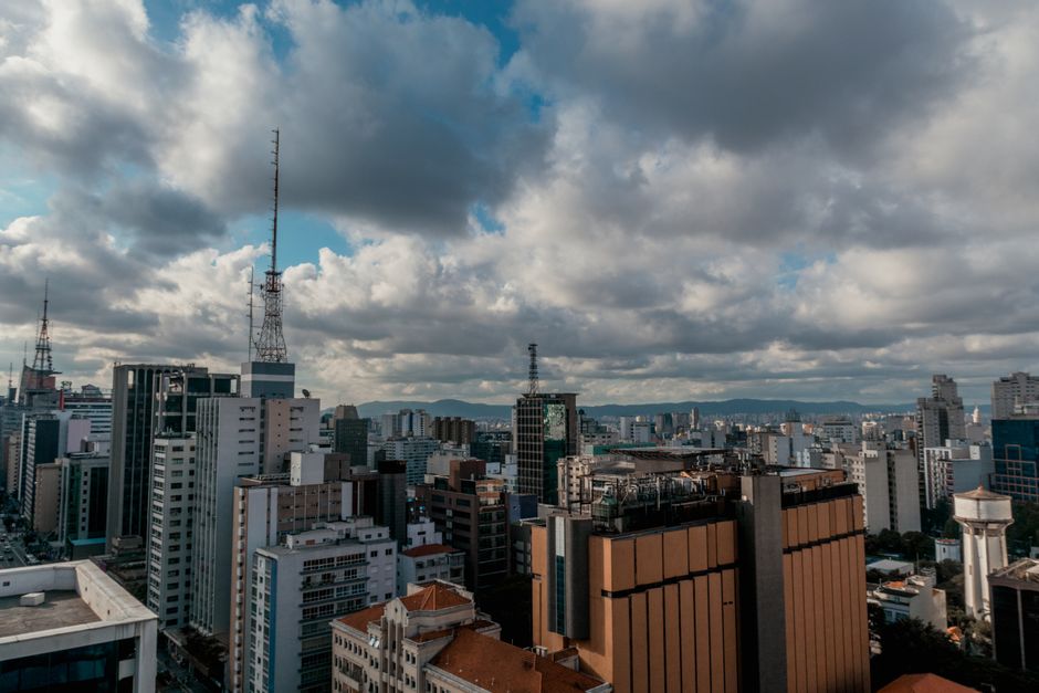 Vista aérea de un moderno horizonte de ciudad con altos edificios bajo un cielo nublado.