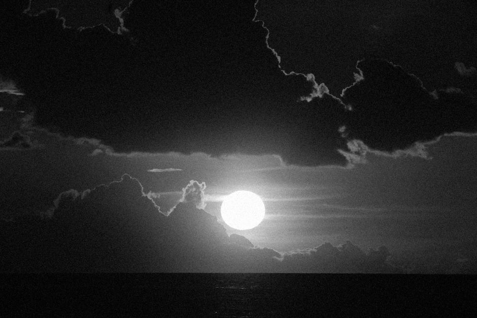 Una imagen cautivadora en blanco y negro de la luna rodeada de nubes dramáticas por la noche.