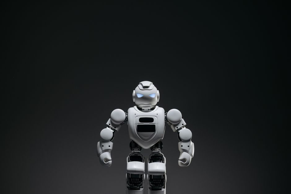 Primer plano de un robot de juguete blanco con ojos que brillan en un entorno de estudio.