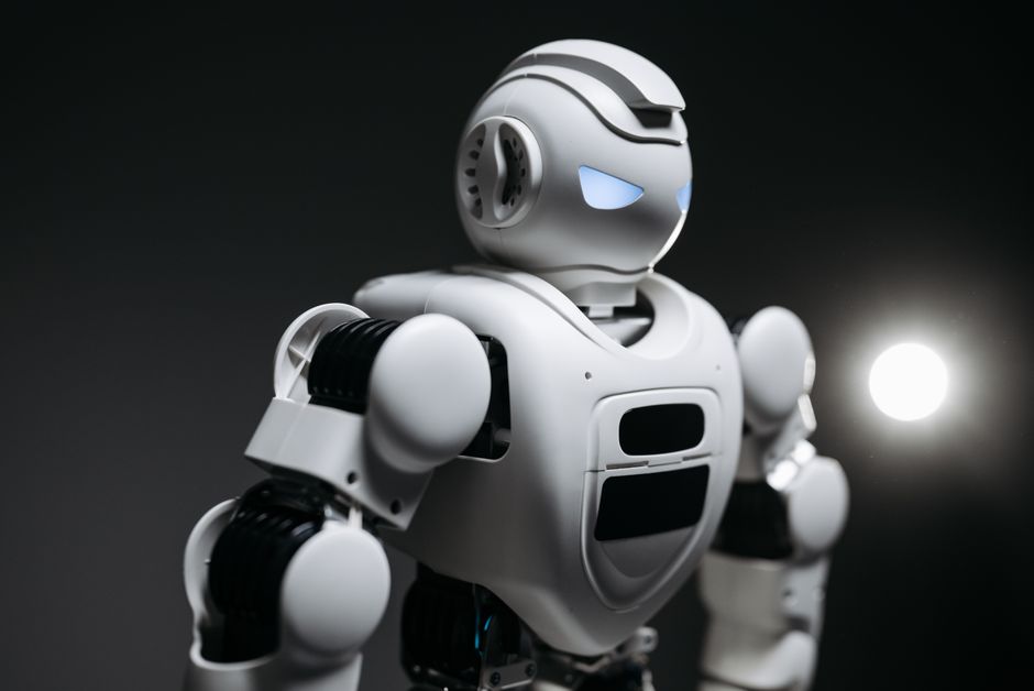 Imagen en primer plano de alta definición de un robot blanco con ojos luminosos en iluminación de estudio. Innovación tecnológica moderna.