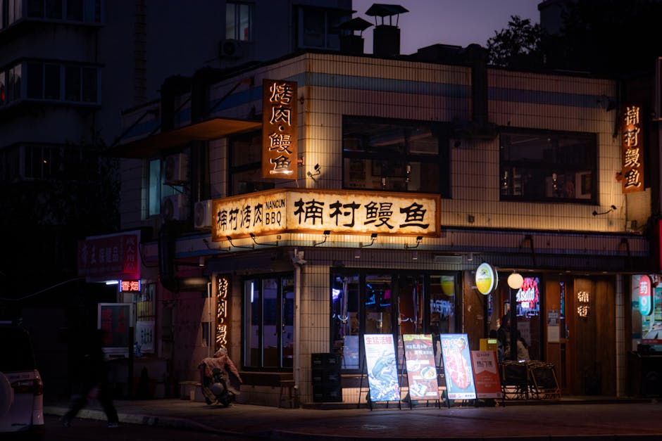 Ambiente cálido por la noche en un restaurante de barbacoa tradicional con carteles iluminados y una tranquila esquina de calle.