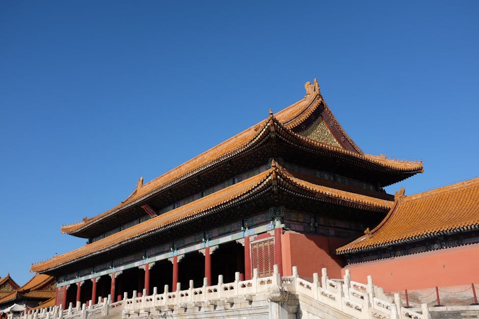 Una vista impresionante de la Ciudad Prohibida de Pekín bajo un cielo azul despejado, que muestra la arquitectura tradicional china.
