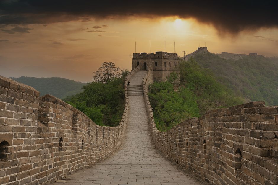 Impresionante vista de la Gran Muralla China al amanecer con colores cálidos y caminos vacíos.