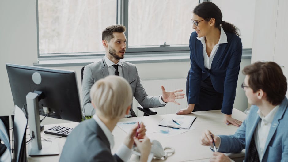 Un equipo de profesionales mantiene una conversación en un entorno de oficina moderno.