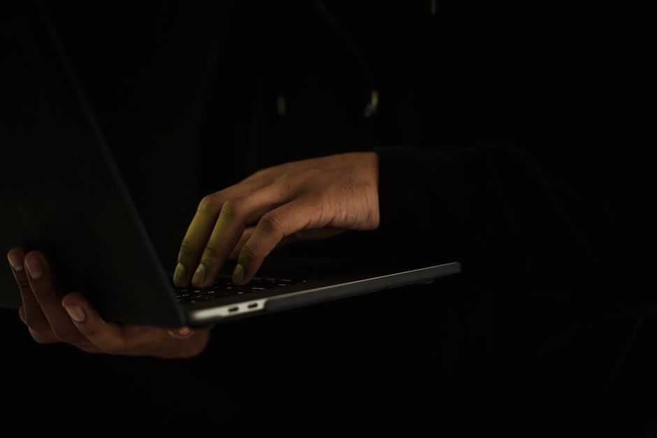 Recortar Hombre Irreconocible Escribiendo En La Computadora Portátil En La Oscuridad