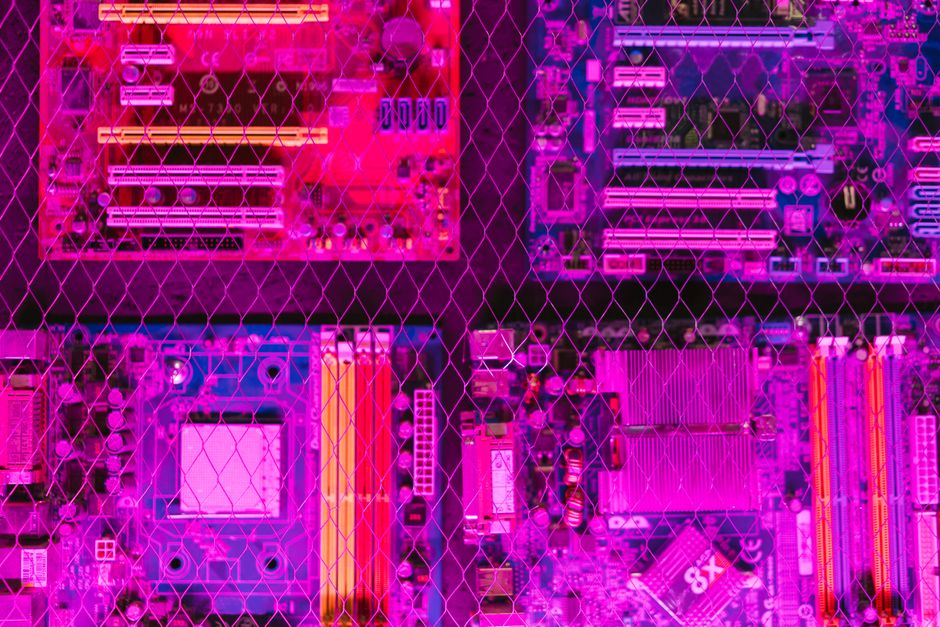 Una imagen vibrante que muestra diversas placas de circuitos a través de una rejilla de alambre, destacando la electrónica y la tecnología.