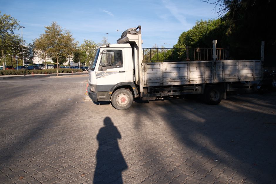 Un camión de plataforma estacionado en un día soleado en Esmirna, Turquía. La sombra sobre el pavimento le añade un toque de misterio.