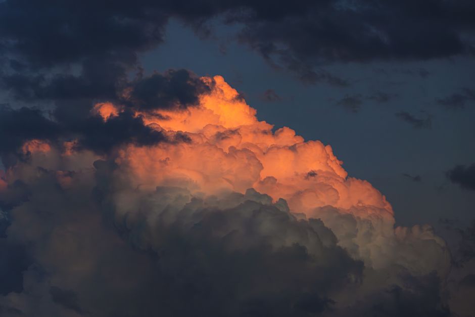 Una vista impresionante de nubes espectaculares iluminadas por los colores del atardecer, creando una atmósfera vívida y melancólica.