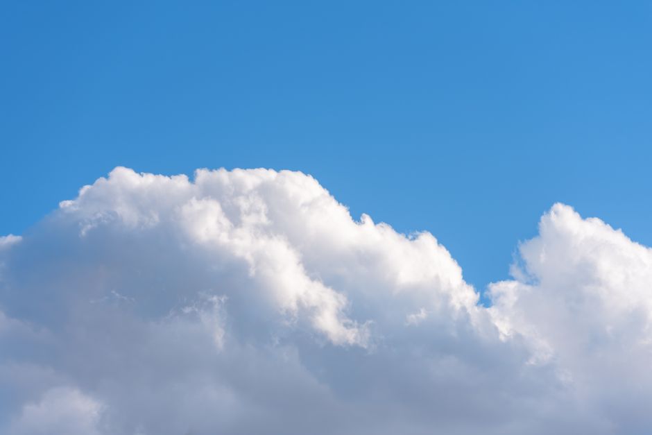 Un cielo sereno con nubes blancas y esponjosas sobre un fondo azul claro, perfecto para ambientes tranquilos y apacibles.