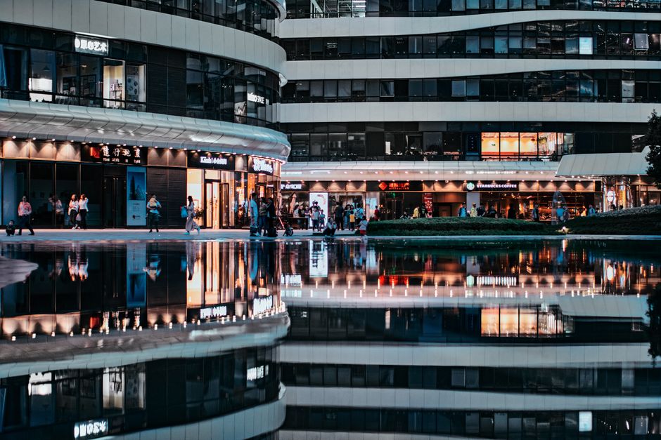 Vista reflexiva de la agitada arquitectura moderna en Pekín, capturando la vida urbana por la noche.