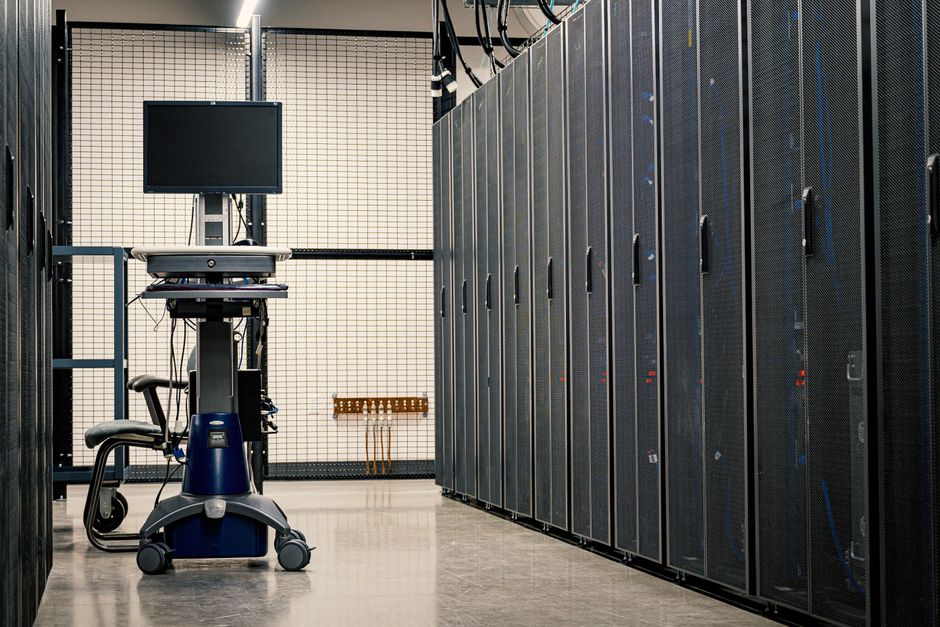 Interior de centro de datos que muestra estantes de servidores y equipos de operación.