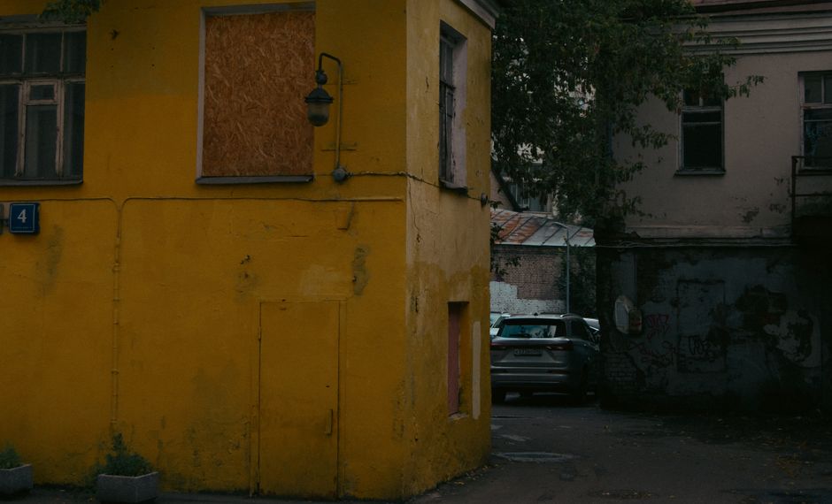 Un edificio de un amarillo vibrante en una tranquila esquina de Moscú, que evidencia la decadencia urbana.
