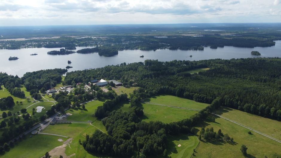 Impresionante vista aérea de un paisaje sueco con bosques exuberantes y un lago sereno.