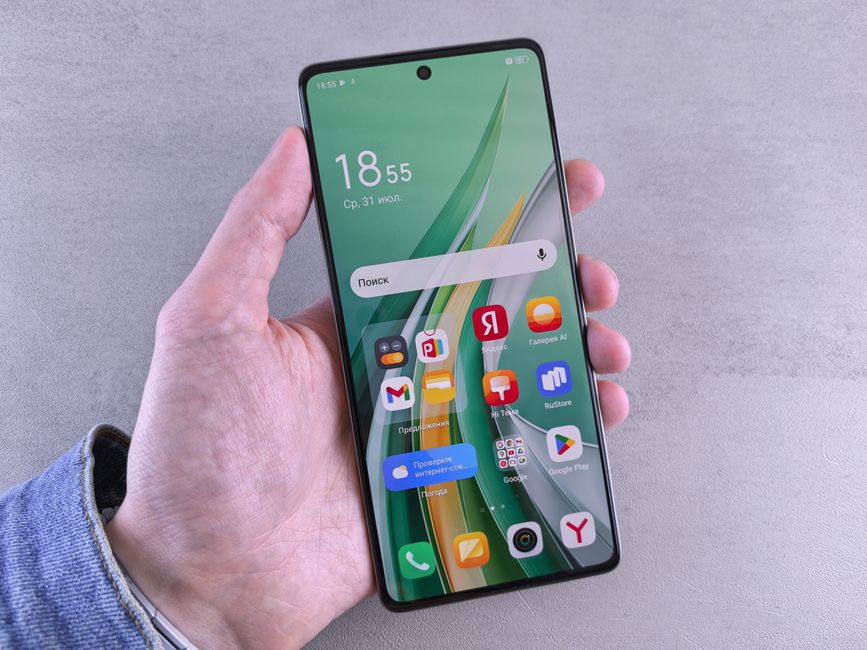 Primer plano de una mano que sostiene un teléfono inteligente con una pantalla vibrante llena de aplicaciones sobre un fondo neutro.