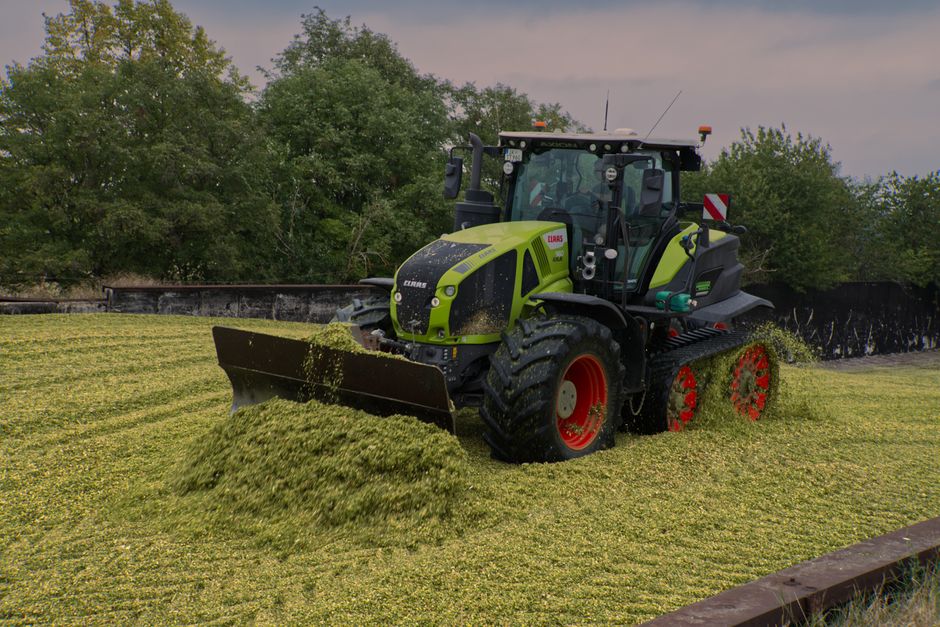 Un tractor ara un campo de cultivo rodeado de una densa vegetación.